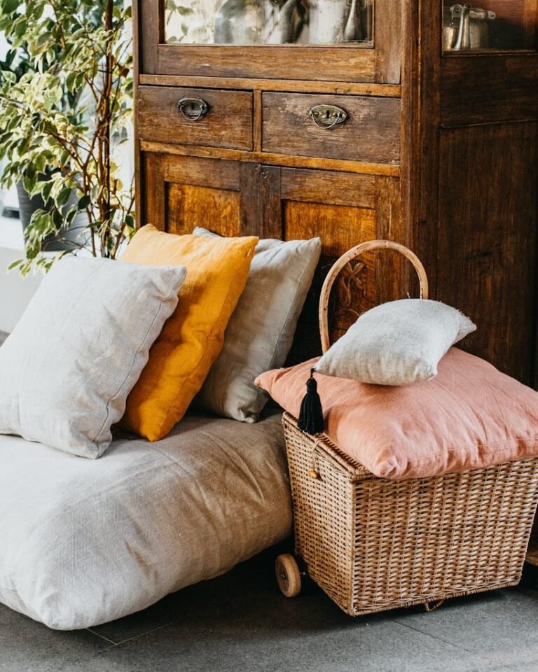 Warm rustic interior with cushions and a wicker basket beside a vintage cabinet