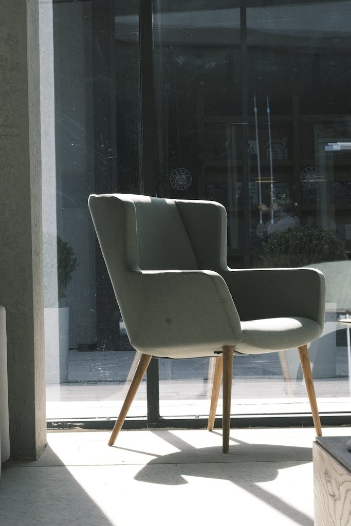 Stylish armchair bathed in sunlight beside a glass window in a modern living room